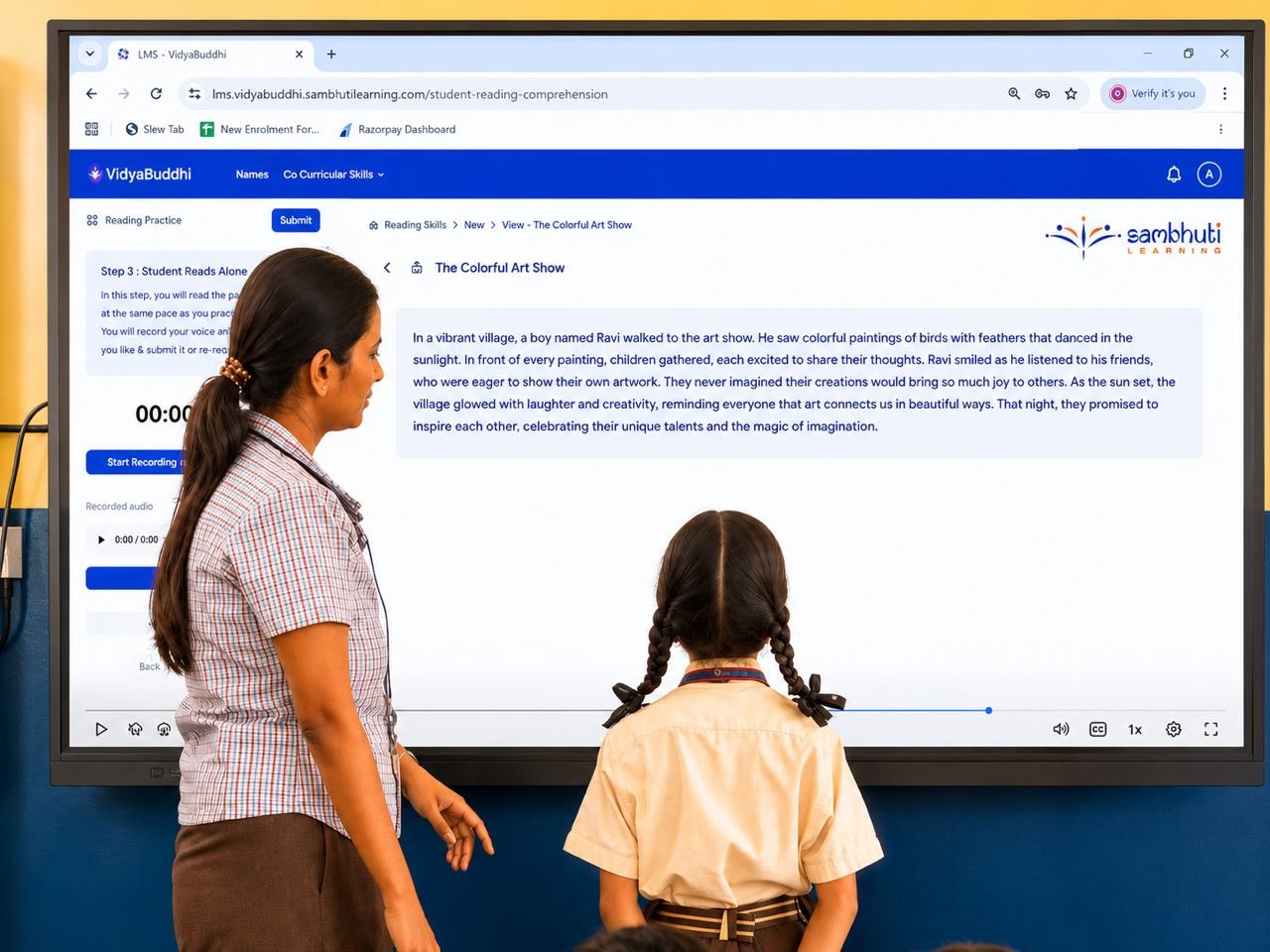 A student reading a passage on the VidyaBuddhi smart board while the teacher watches